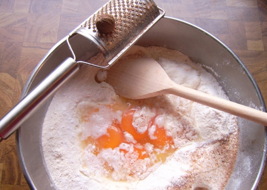 In einer Schüssel Mehl mit Salz, Pfeffer und ein wenig Backpulver vermischen, dann Eier und etwas Wasser dazugeben.